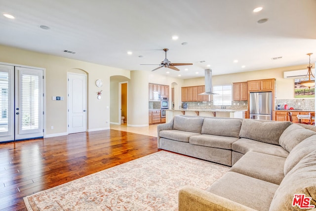 living room featuring ceiling fan and light hardwood / wood-style floors