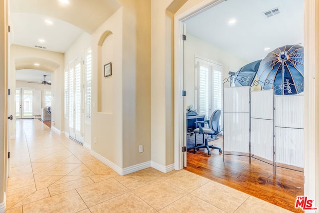 hallway featuring light tile patterned floors and a healthy amount of sunlight