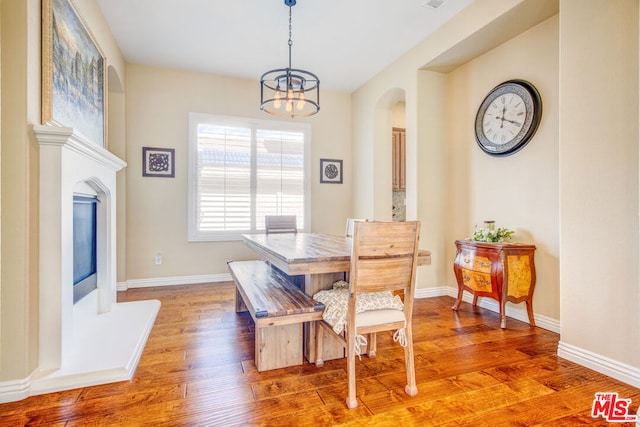 dining space with light hardwood / wood-style floors and a notable chandelier