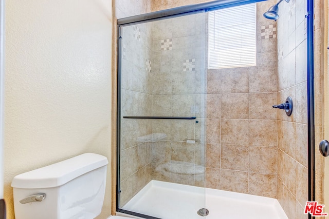 bathroom with an enclosed shower and toilet