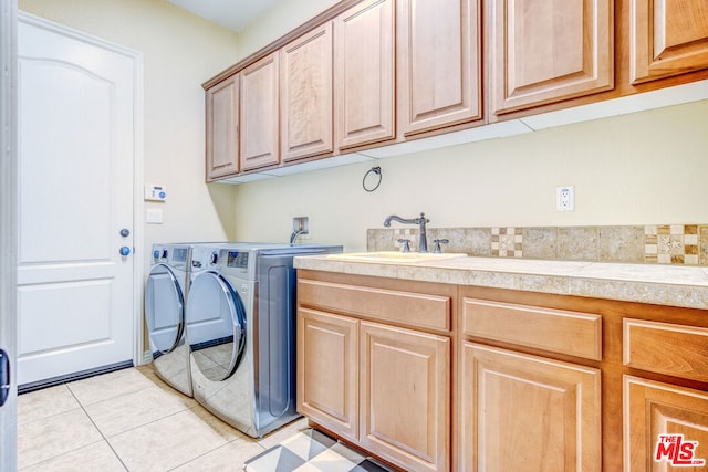 laundry room with independent washer and dryer, cabinets, light tile patterned flooring, and sink