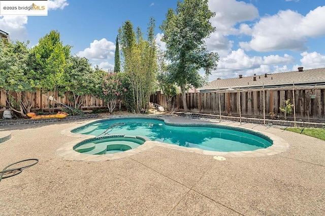 view of swimming pool with an in ground hot tub and a patio