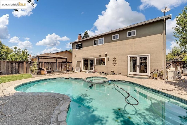 view of swimming pool featuring a gazebo, an in ground hot tub, a patio area, and french doors