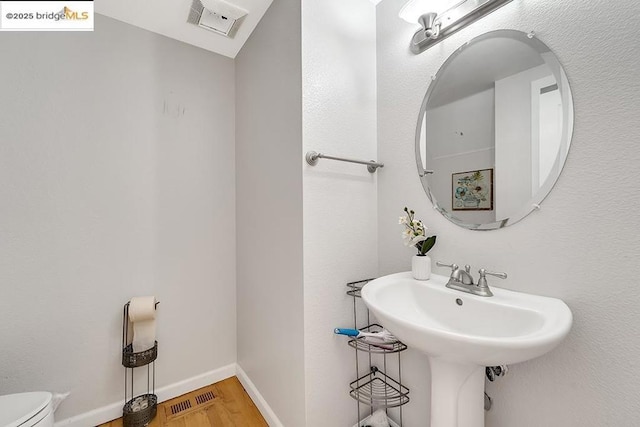 bathroom with wood-type flooring, sink, and toilet