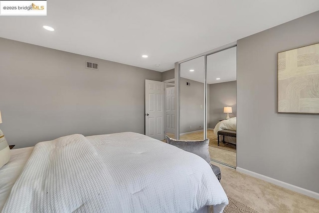 bedroom featuring light colored carpet and a closet