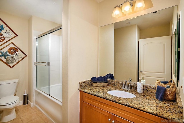 full bathroom featuring vanity, bath / shower combo with glass door, tile patterned floors, and toilet