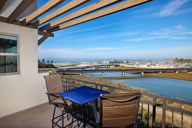 balcony featuring a pergola and a water view