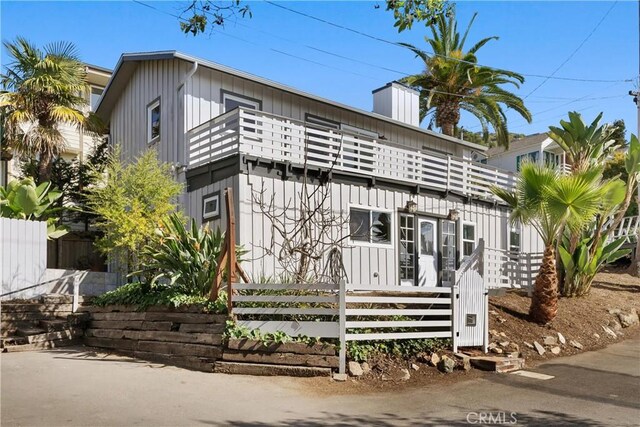 31955 10th Ave, Laguna Beach, CA 92651 - view of front of home featuring a balcony, a fenced front yard, and board and batten siding