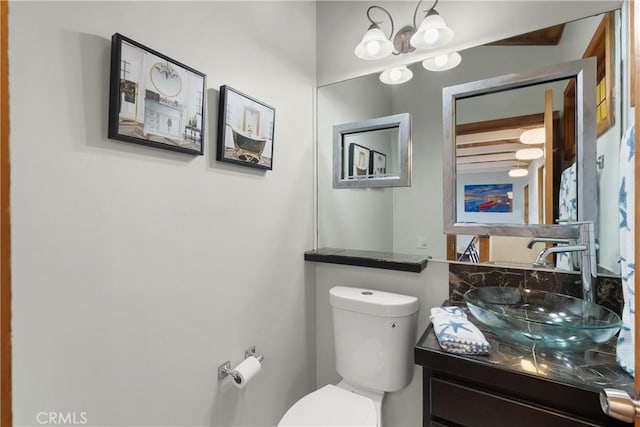 bathroom featuring vanity, a notable chandelier, and toilet