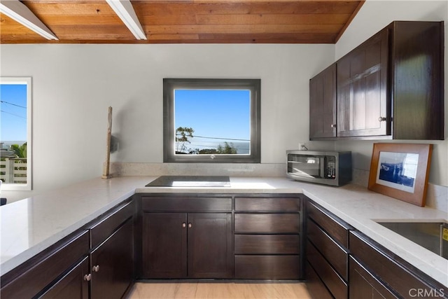 kitchen with dark brown cabinetry, wood ceiling, beam ceiling, and light wood-type flooring