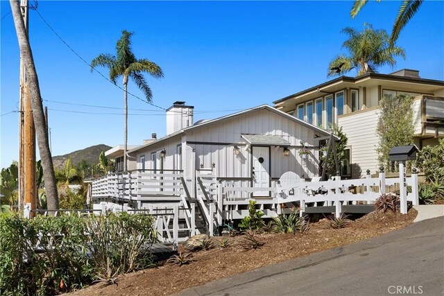 31955 10th Ave, Laguna Beach, CA 92651 - view of front of house with a deck with mountain view and a chimney