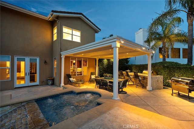 view of pool with area for grilling, a patio, and french doors