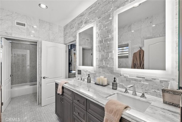 bathroom featuring tile walls, vanity, tasteful backsplash, tile patterned floors, and walk in shower