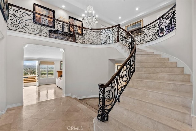 staircase with a high ceiling and an inviting chandelier