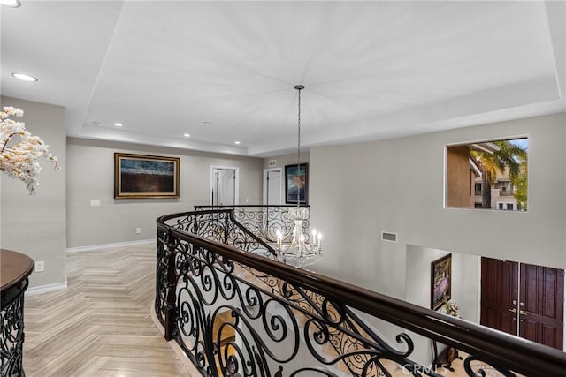 corridor featuring an inviting chandelier and light parquet floors