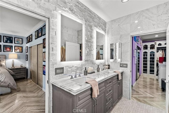 bathroom with vanity, crown molding, parquet flooring, and tile walls