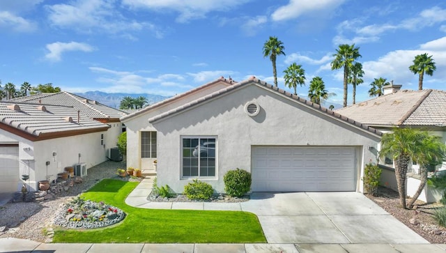 view of front of house featuring a garage and central AC