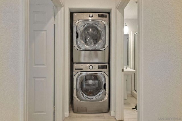 washroom featuring stacked washer and dryer and light wood-type flooring