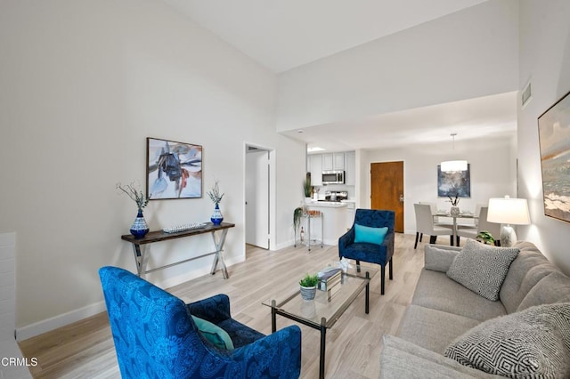 living room featuring light hardwood / wood-style flooring and a high ceiling