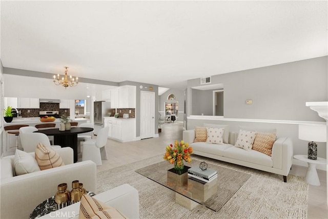 living area with visible vents and an inviting chandelier