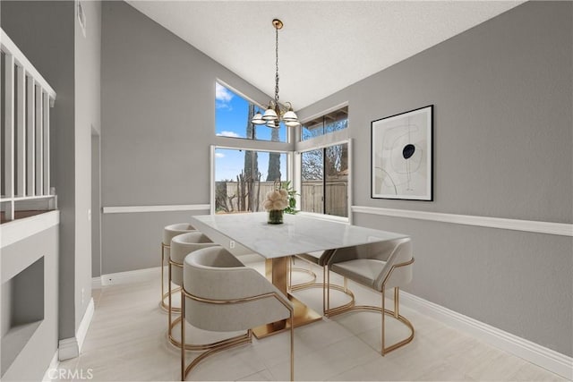 dining area featuring a chandelier and high vaulted ceiling