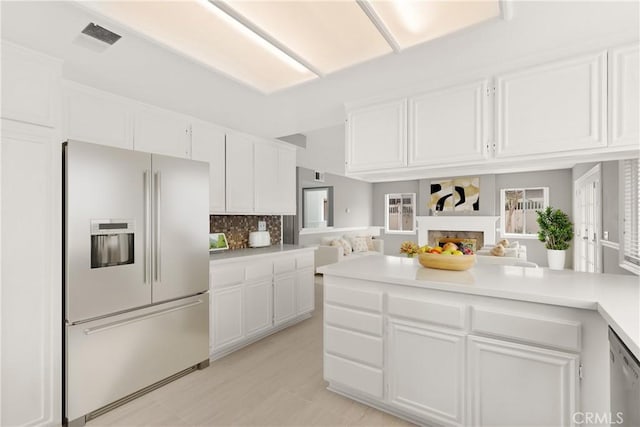 kitchen with stainless steel appliances, visible vents, light countertops, and white cabinetry