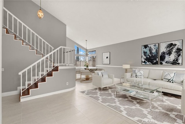 living room featuring stairs, tile patterned floors, a notable chandelier, and high vaulted ceiling