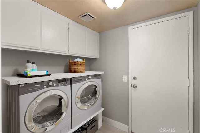 laundry area featuring visible vents, cabinet space, baseboards, and separate washer and dryer