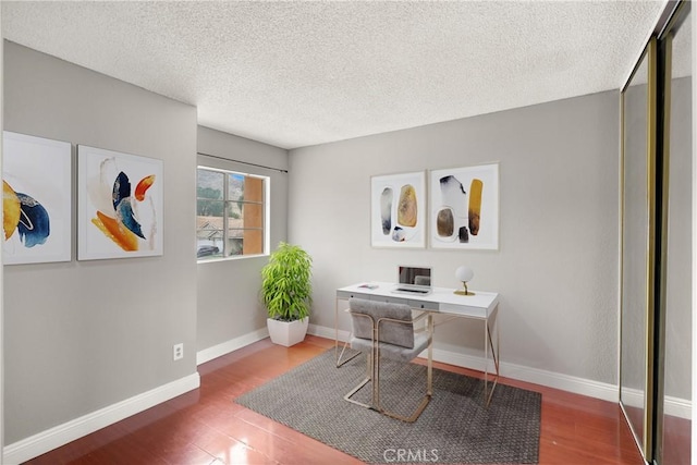 office featuring wood finished floors, baseboards, and a textured ceiling