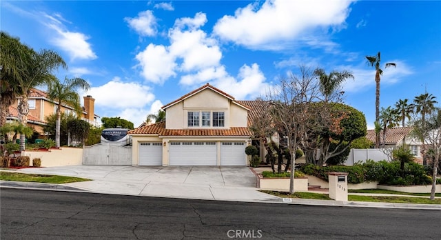 mediterranean / spanish-style house featuring concrete driveway, a tiled roof, fence, and stucco siding