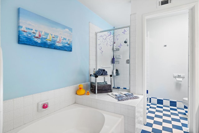 bathroom featuring toilet and shower with separate bathtub