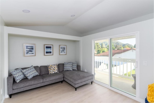 living room featuring lofted ceiling and light wood-type flooring