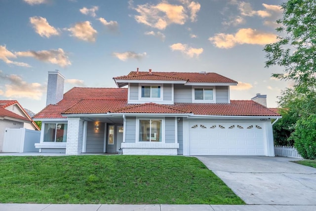 view of front of house with a garage and a lawn