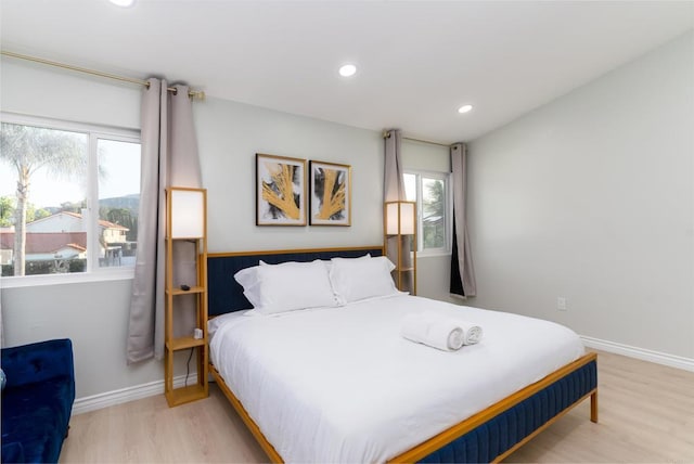 bedroom with multiple windows and light hardwood / wood-style floors