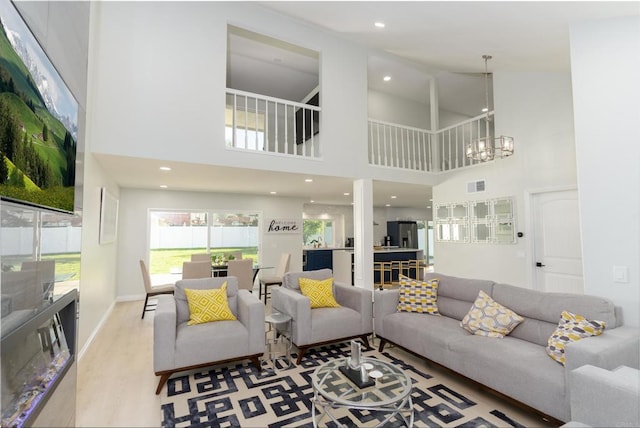 living room featuring wood-type flooring and an inviting chandelier