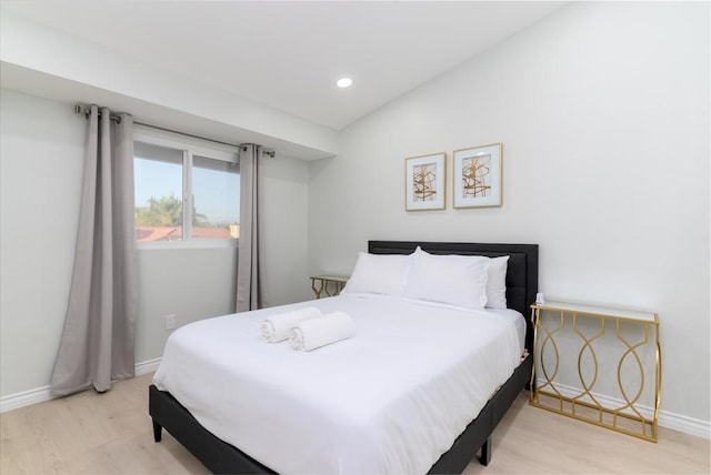 bedroom featuring lofted ceiling and light hardwood / wood-style floors