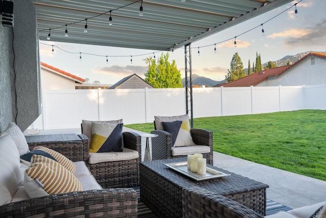 patio terrace at dusk featuring outdoor lounge area and a yard