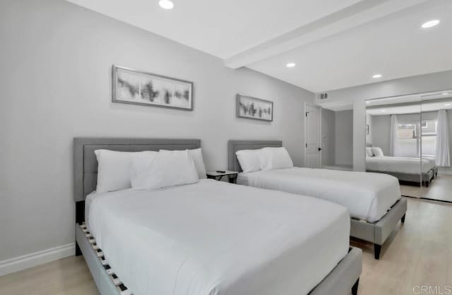 bedroom featuring beamed ceiling and light hardwood / wood-style floors