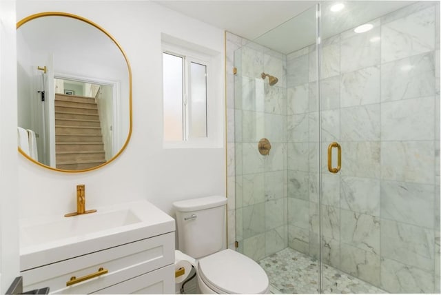 bathroom featuring vanity, toilet, and a shower with shower door