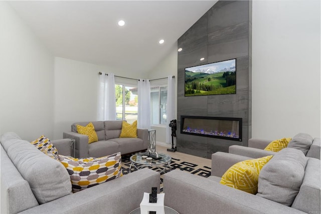 living room featuring vaulted ceiling, a large fireplace, and hardwood / wood-style floors