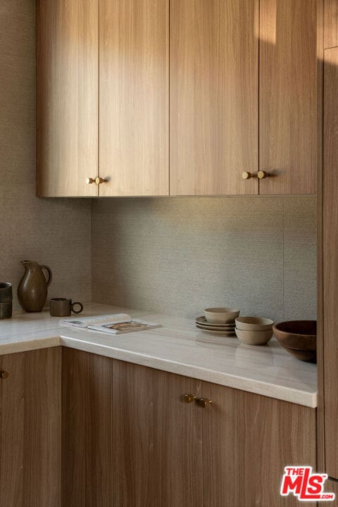 kitchen featuring tasteful backsplash and light stone counters