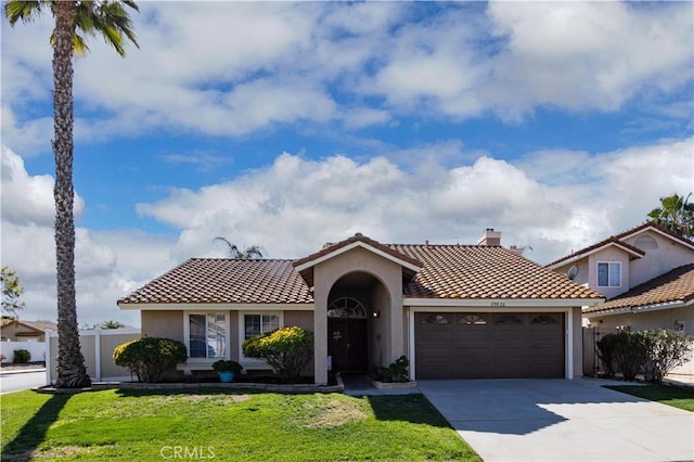 mediterranean / spanish-style home with a front yard and a garage