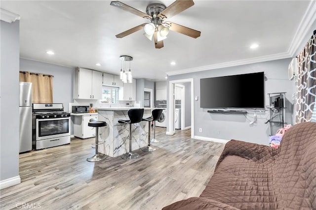 living room with crown molding, ceiling fan, and light hardwood / wood-style flooring