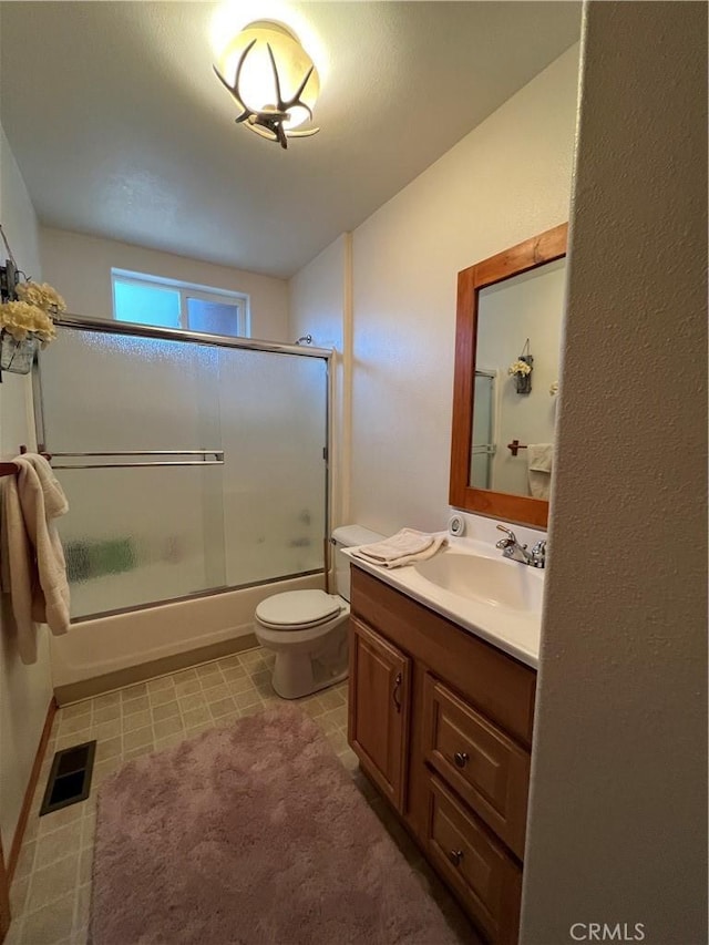 full bathroom featuring vanity, toilet, and combined bath / shower with glass door