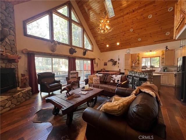 living room with dark hardwood / wood-style floors, wood ceiling, a stone fireplace, and a chandelier