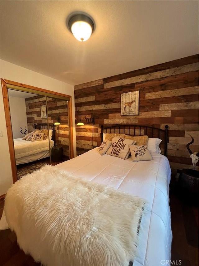 bedroom featuring wooden walls and a closet