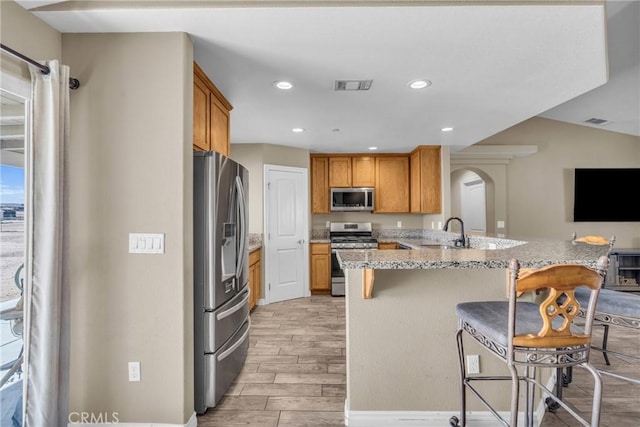 kitchen featuring appliances with stainless steel finishes, sink, a breakfast bar area, and kitchen peninsula