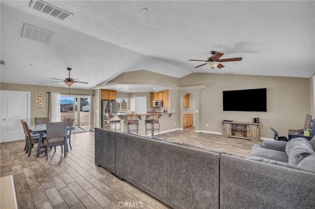 living room with vaulted ceiling, light hardwood / wood-style floors, and ceiling fan