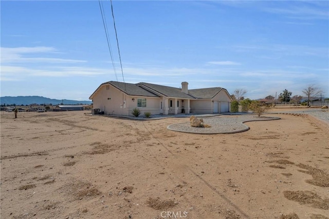 back of property featuring a garage and a mountain view