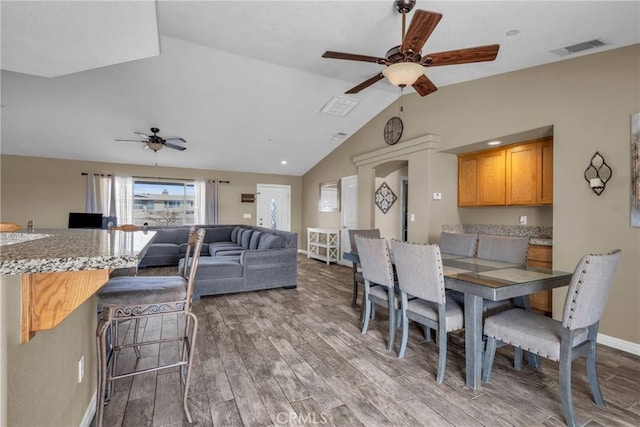 dining room featuring hardwood / wood-style flooring, ceiling fan, and lofted ceiling